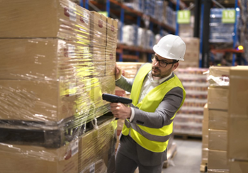 Man in a warehouse scanning a pallet's barcode