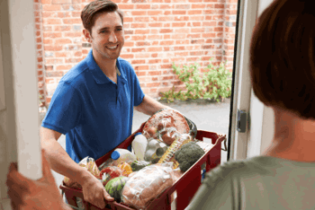 Man delivering grocery subscription in a basket