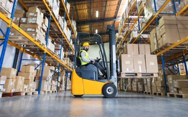 man driving a forklift picking up pallets for a b2b order